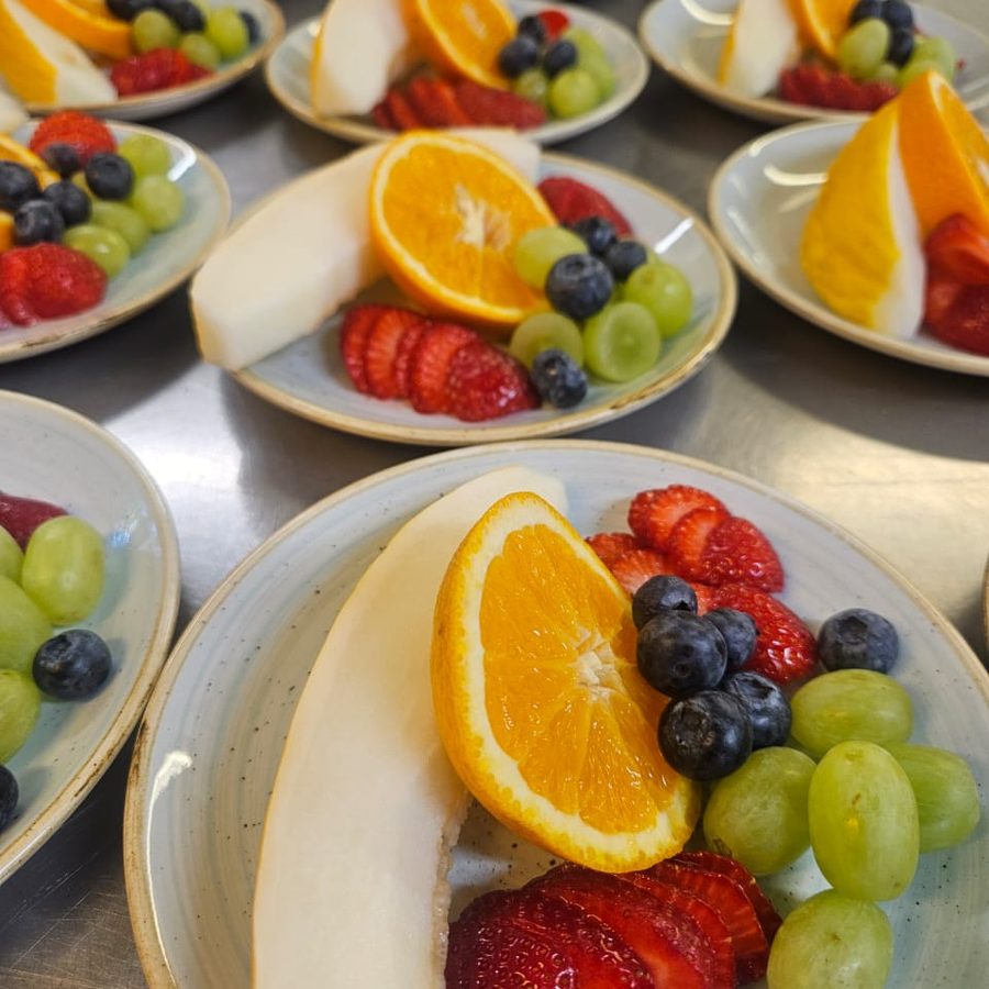 Individually plated fruit with orange, strawberries, grapes and melon