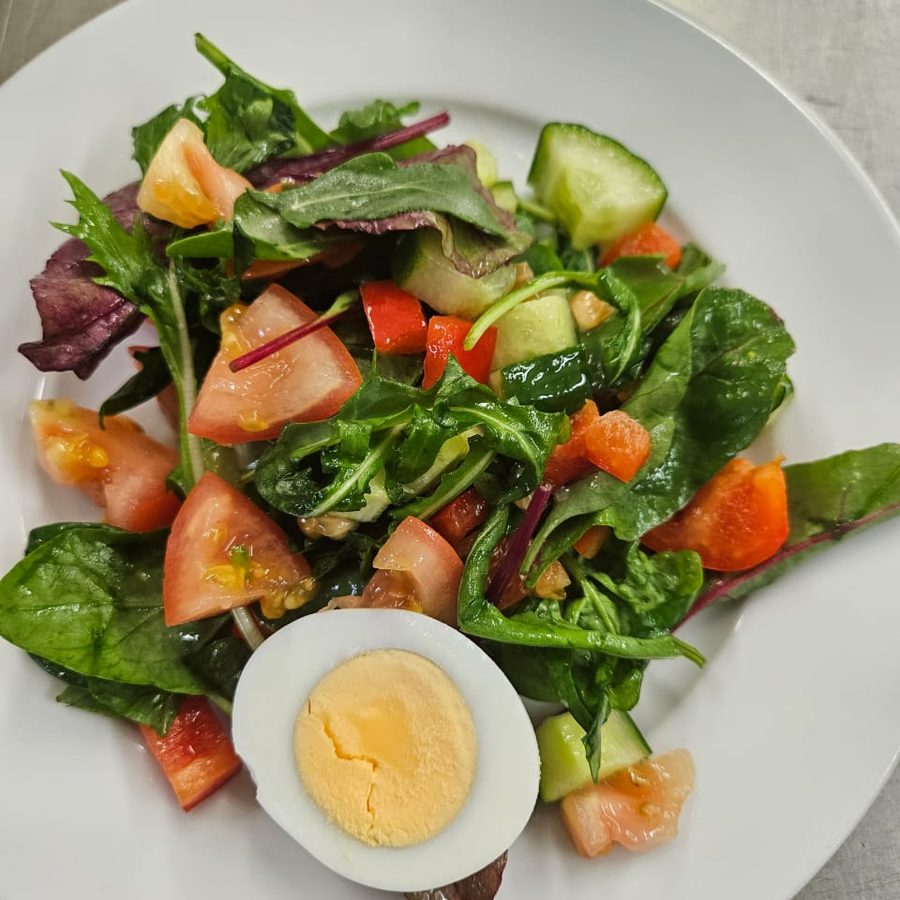 A fresh garden salad plated with egg