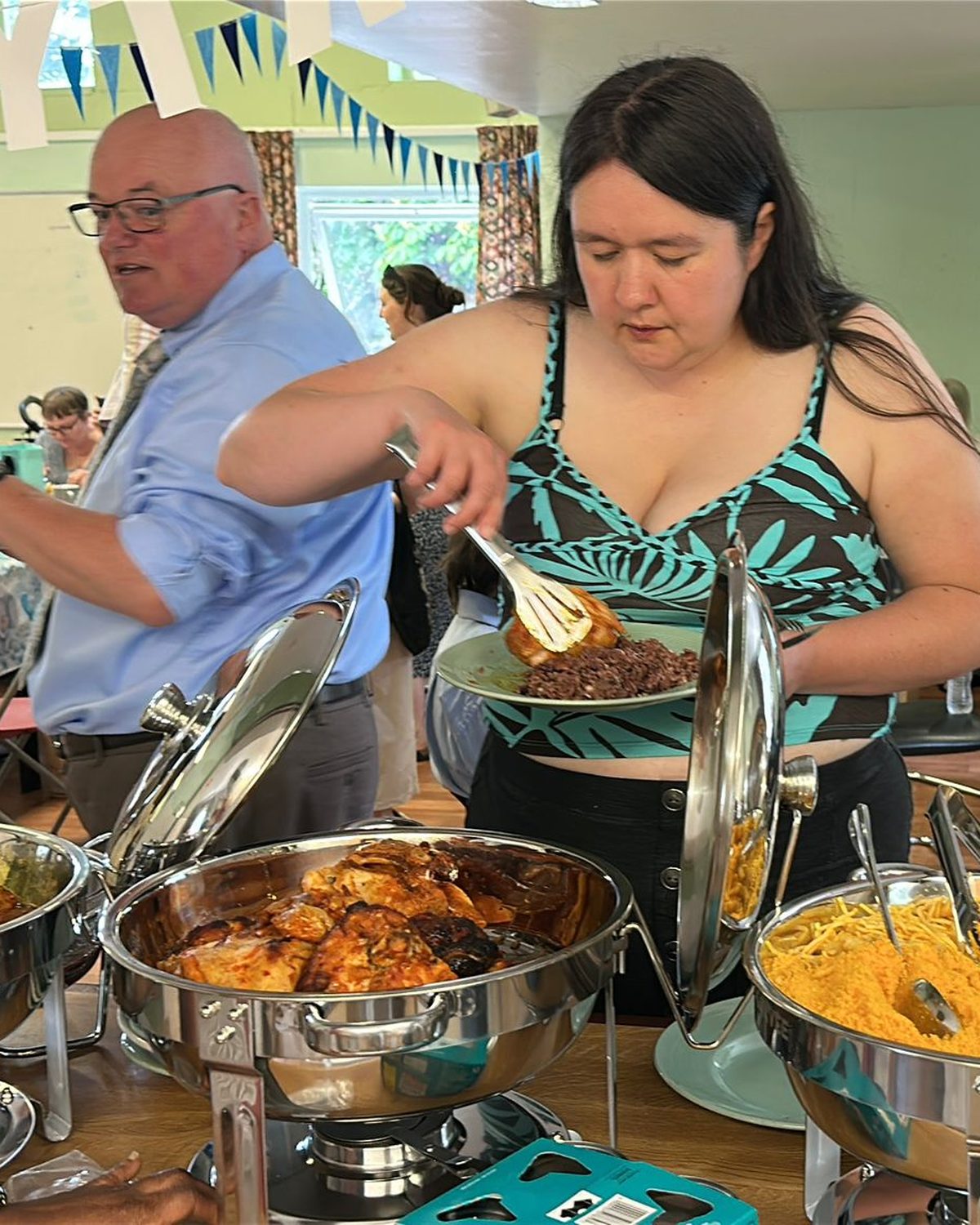 Guests serving themselves from the hot buffet at a party catered by Marie Flair&rsquo;s Culinary